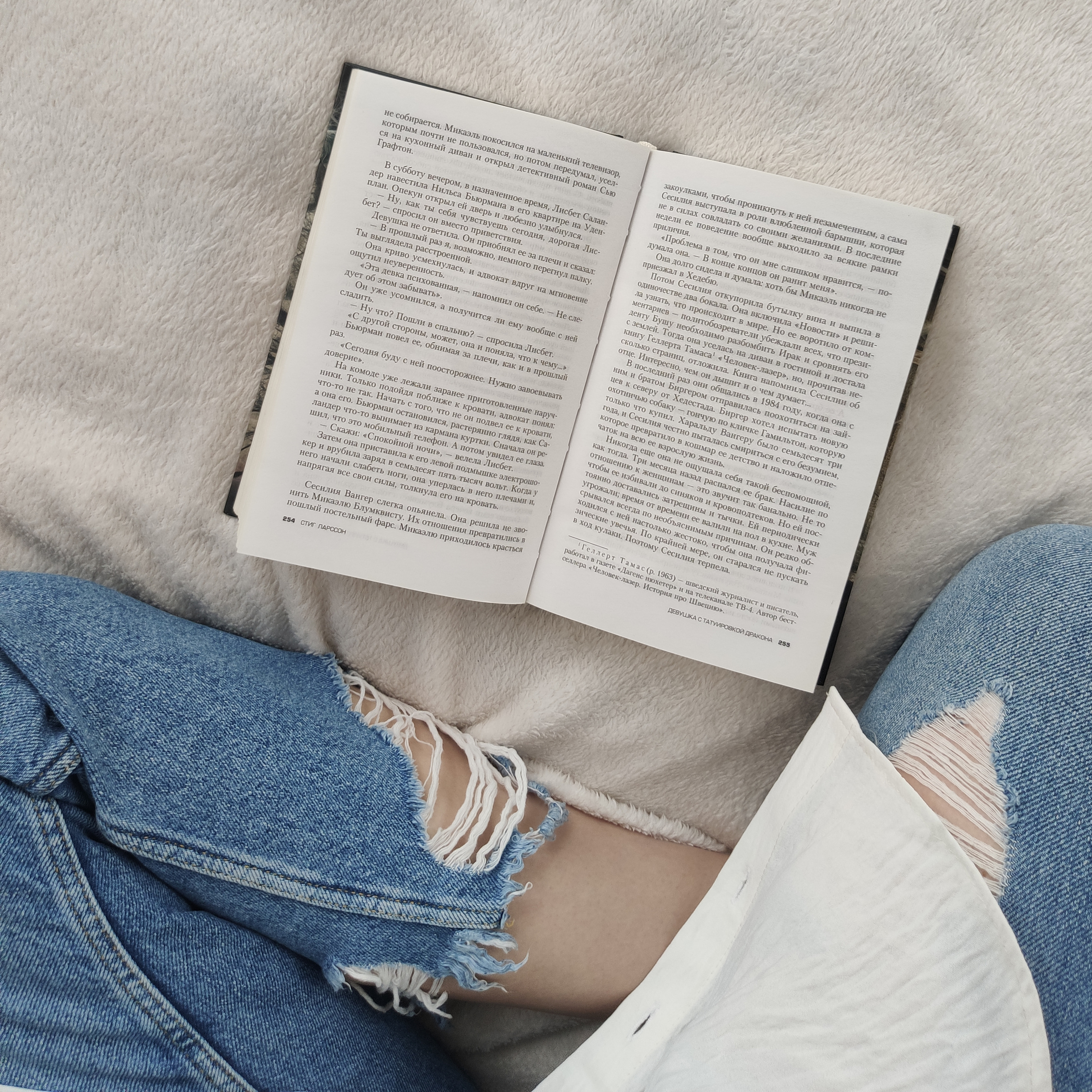 Crop unrecognizable woman reading book on soft bed